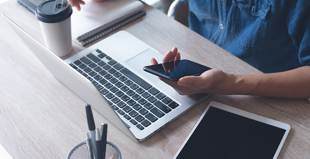 Bezdrôtové pripojenie Muž používa smartfón a notebook